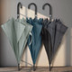 A collection of three Pegasus Hook Umbrellas in green, teal, and dark grey, each featuring a curved handle.