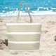 An insulated cooler bag in light grey with white stripes, set against a beach background. An insulated cooler bag in light grey with white stripes, set against a beach background.