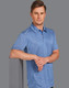 A blue short sleeve polo shirt with a subtle texture and a logo. The model stands casually with arms crossed.