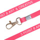 A bright pink PVC lanyard with a metal clip, featuring branding along its length.
