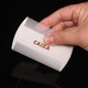 A white pet flea comb held in a hand, featuring fine teeth for removing fleas. It has a branding logo on the side.