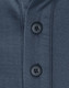 A close-up of a men's sustainable poly/cotton polo shirt in a dark colour, featuring two black buttons at the collar. A close-up of a men's sustainable poly/cotton polo shirt in a dark colour, featuring two black buttons at the collar.