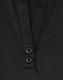 A close-up of a black polo shirt featuring a collar and two buttons at the neckline. The shirt has a logo.