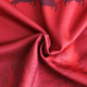 A red fabric featuring a sublimated design with trees and reindeer patterns, suitable for Christmas sweatshirts.