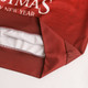 A red polyester spandex Christmas sweatshirt featuring a white interior and seams, with a logo.