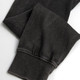 A faded black unisex hoodie showing the detail of the cuffs and sleeves, featuring a subtle texture and a logo.
