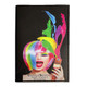 A vibrant, multi-coloured notebook featuring a woman with a rainbow wig, holding paint. It has a branding logo.