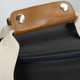 A wine cooler bag featuring a sleek black exterior and a brown leather handle, with metal rivets for added durability.
