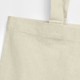 A recycled cotton tote bag in a light beige colour with sturdy shoulder straps and visible stitching details.