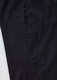A close-up of black cargo pants featuring a large side pocket and a subtle logo on the waistband.