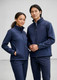 A navy men's softshell jacket displayed on a male and female model, both wearing coordinating attire.