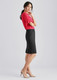A woman in a red top and black wool stretch multi-pleat skirt stands elegantly, paired with nude heels.