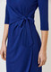 A blue dress featuring a tied detail at the waist and three-quarter sleeves. The dress has a smooth, elegant look.