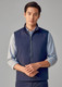 A navy unisex reversible fleece vest with a zip front and a logo on the chest, modelled by a man.