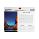 A calendar mouse mat featuring a scenic image and a layout of months in grey and white. It also includes a logo.