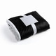 A black and grey fleece blanket, neatly folded and secured with a white band. It features a soft texture.