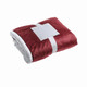 A folded maroon blanket with a white edge, secured with a white band and tag.