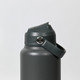A drink bottle in a dark grey colour with a secure lid and a carrying strap. It features a logo on the body.