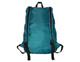 A teal fold-up backpack with black straps, featuring a zippered pocket and a logo. Ideal for easy storage.