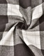 A close-up of grey and white flannel fabric with a plaid pattern, showing the texture and weave.
