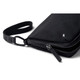 A black toiletry bag with a zippered closure and a detachable strap, featuring a discreet logo.