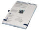 A light grey A5 notebook with a spiral binding, featuring a logo and contact information on the cover.