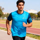 A man jogs in a vibrant blue and navy 100% polyester sublimated tee shirt with a logo on it.