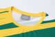 A green and yellow striped long-sleeved sports shirt featuring a round neck and a logo on the label.