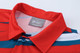 A red polo shirt featuring horizontal stripes in blue and white, with a collar and a brand label in the neckline.