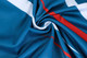 A blue polyester fabric with white and red stripes, showcasing a textured pattern suitable for sports polo shirts.