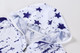 A hooded shirt in white with blue stars and a quarter-zip design, featuring a logo on the collar.
