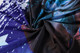 A close-up of a fabric featuring a vibrant design with shades of blue, black, and purple, showcasing an intricate pattern.