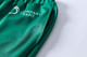 Green unisex adult sports shorts made from 100% polyester, featuring a side pocket and a logo.