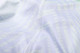 A close-up of a light-coloured, patterned fabric showcasing stitching details of a V-neck shirt.