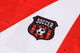 A red and white unisex football jersey featuring a shield-shaped logo with a soccer ball.