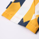 A close-up of a button-up shirt featuring a bold pattern in yellow, navy, and white with visible stitching.