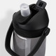 A drink bottle made of grey plastic with a black cap and handle, featuring a flip straw and a logo.