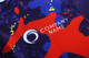 A long-sleeve cycling jersey featuring a vibrant design in blue, red, yellow, and purple, with a logo present.