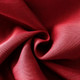 A close-up view of red polyester spandex fabric, showcasing its smooth texture and soft drape.