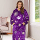 A purple unisex wearable blanket with a hood and absorbent lining, featuring celestial patterns and a logo. A purple unisex wearable blanket with a hood and absorbent lining, featuring celestial patterns and a logo.