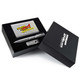 A gift set featuring a pen, a USB drive, and a metallic card, all presented in a black box with branding. A gift set featuring a pen, a USB drive, and a metallic card, all presented in a black box with branding.