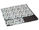 A large picnic rug featuring a geometric pattern in shades of green, blue, and black, with a quilted black underside.