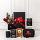 A black gift box tied with a red ribbon contains various items, including a drink bottle, a coffee pack, and a branded pouch.