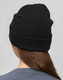 A black beanie made from rPET, displayed from the back on a model with long hair. It features a logo.