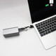 A 100W 3-In-1 aluminium charging cable in silver, connecting a laptop to a power source with a digital display.