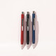 Three ballpoint pens in red, black, and blue, featuring sleek designs and silver clips, displayed against a light background.