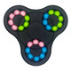 A fidget spinner with three sections, featuring pink, blue, and green balls on a black base. It has a logo.