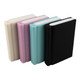 Four book-shaped rubber erasers in cream, pink, teal, and black, featuring rounded edges and varying thicknesses.