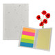 A sticky note pad with a speckled white cover, featuring bright pink, orange, green, and blue sticky notes, alongside red poppy flowers.