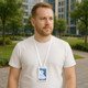 A man wearing a white t-shirt and a white lanyard with an ABS retractable card holder around his neck, outdoors.